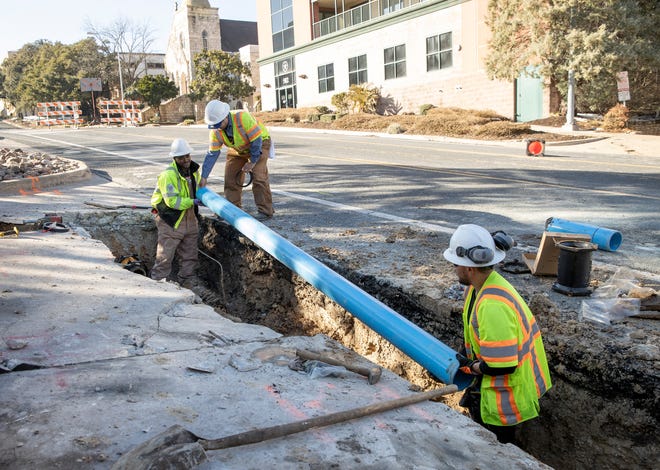 Austin Water workers Joey Putman, Damian Cruz and Salvador Tinajero repair a broken water main near 11th and Red River streets on Feb. 19.