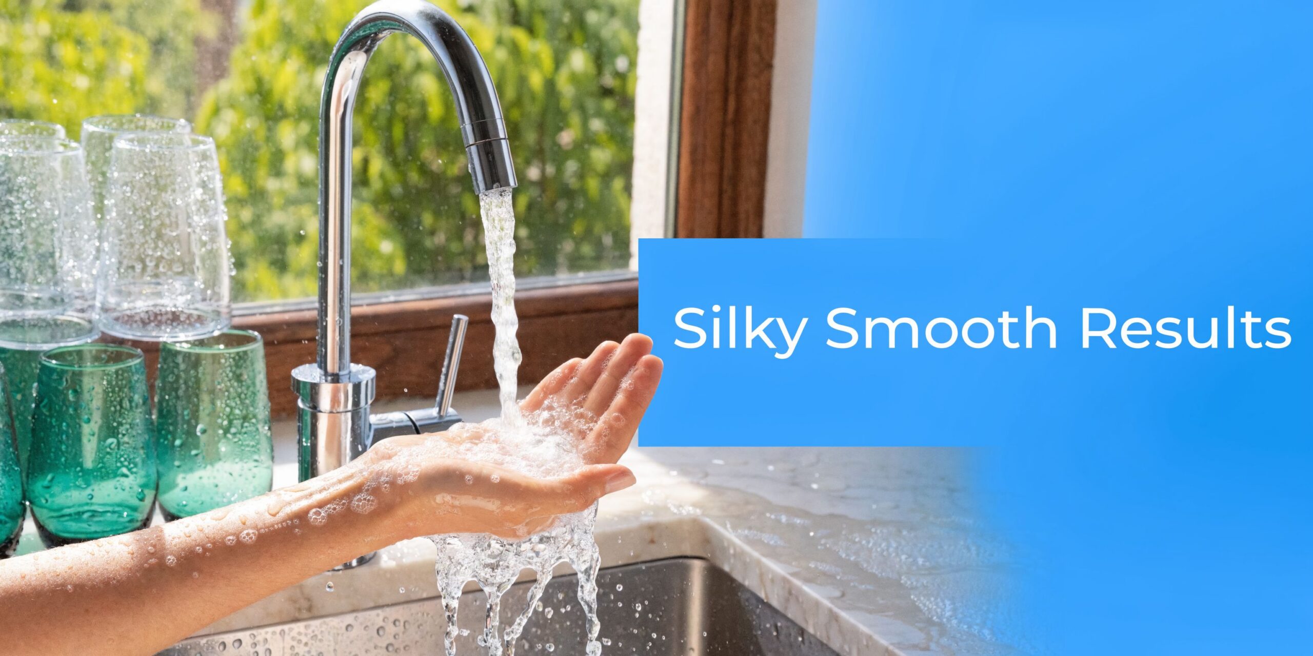 A hand held under a kitchen faucet with running water to demonstrate the feel of soft water.