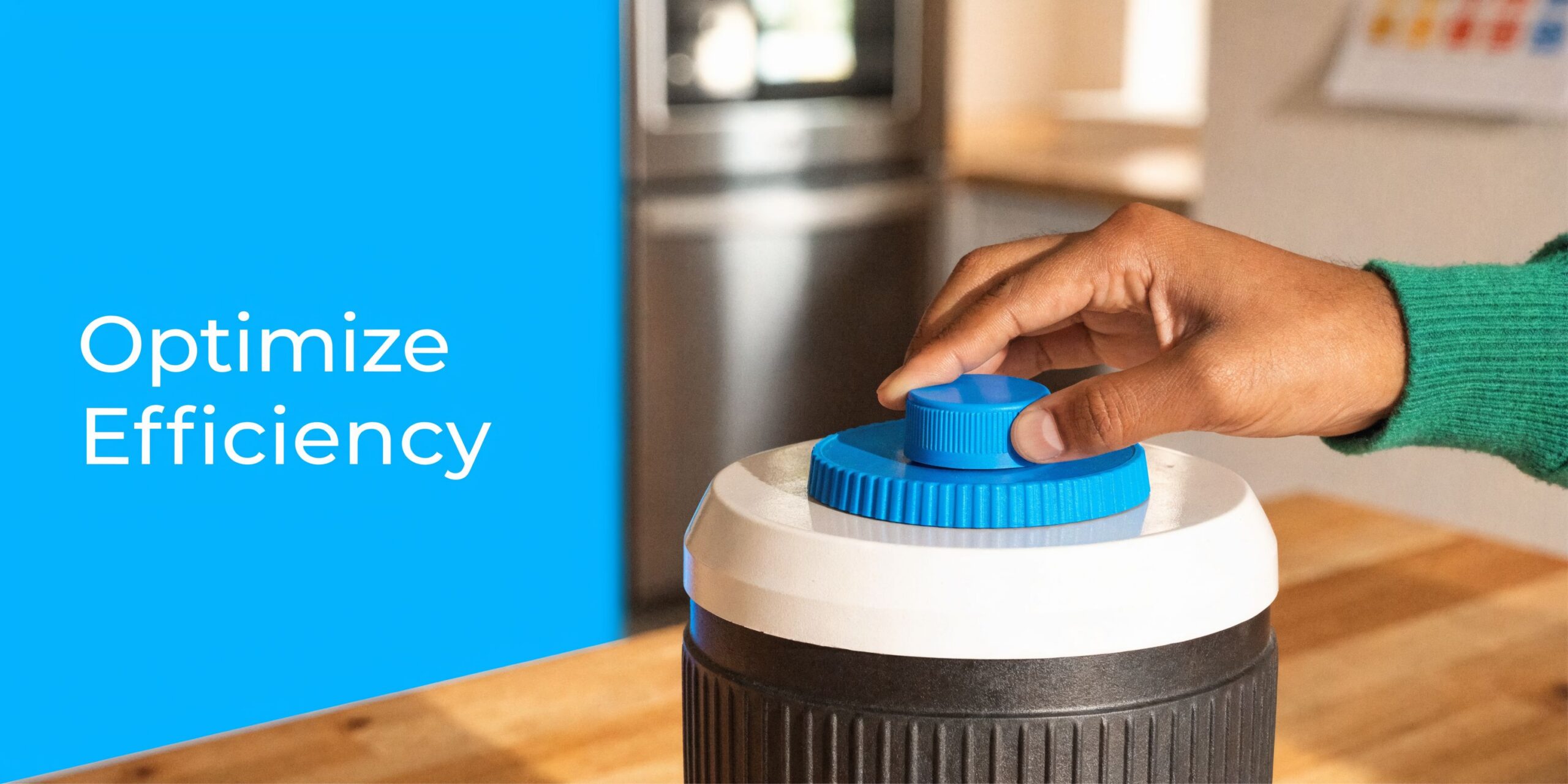 A person's hand adjusting a blue dial on top of a black and white water treatment device.